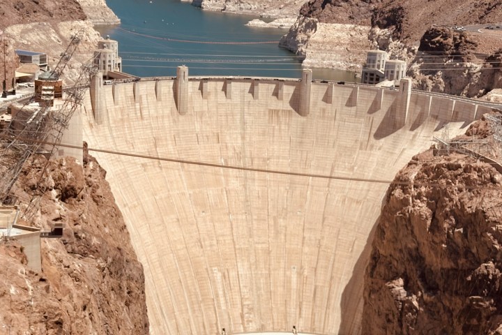 a view of a stone building with Hoover Dam in the background