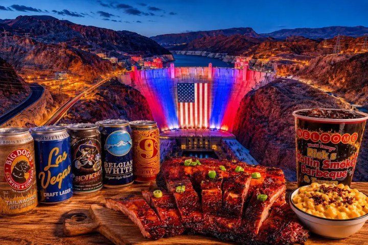 Hoover Dam lit up with flag, BBQ ribs, beans, and craft beer cans on wooden board.